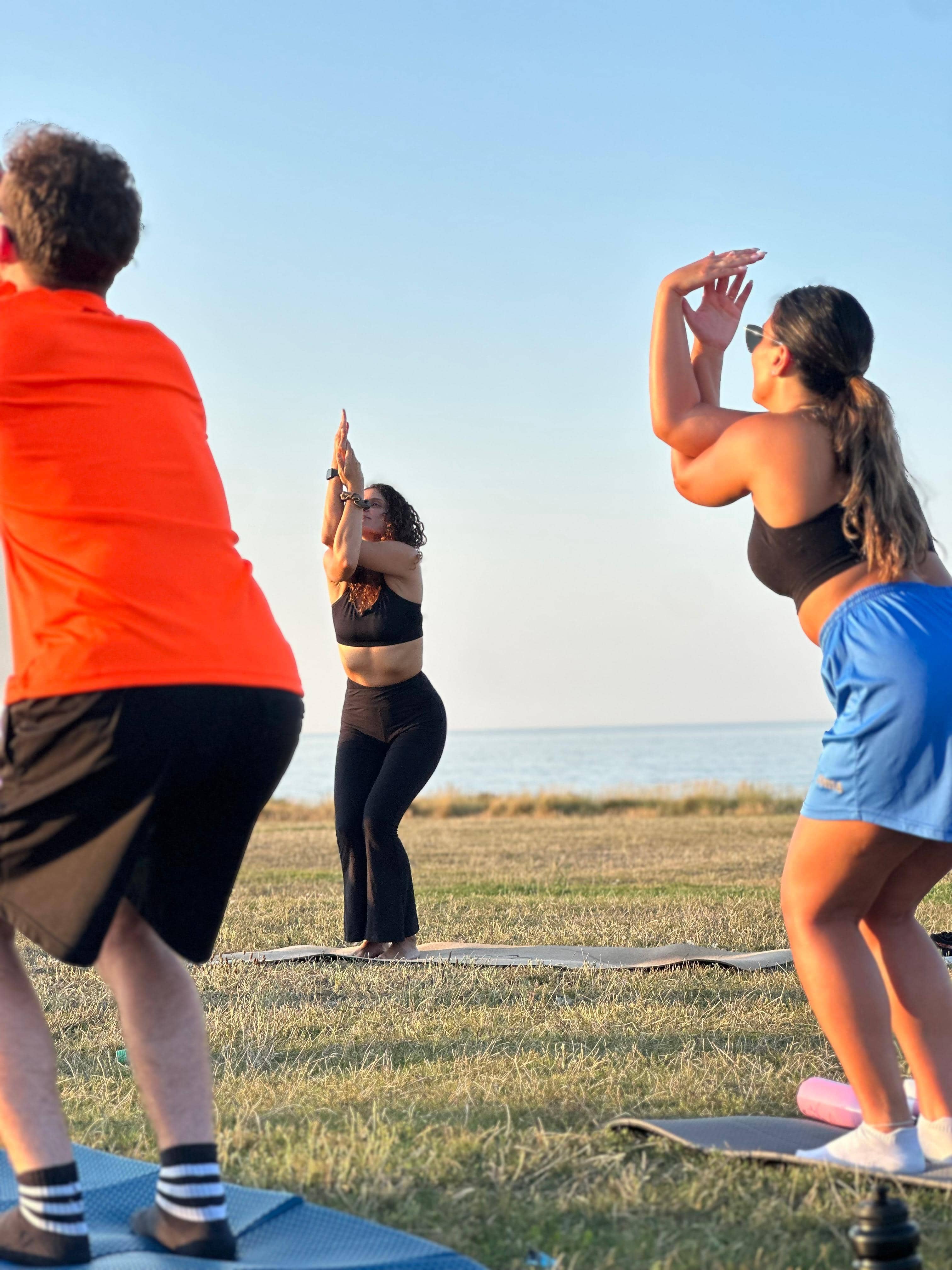 Group yoga session at golden hour by the sea